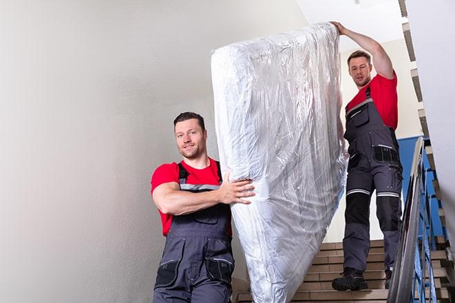 heavy lifting as a box spring is carried out of a house in Duarte